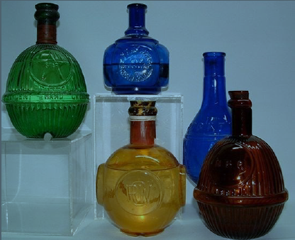 A group of five glass fire grenades in brightly colored hues.