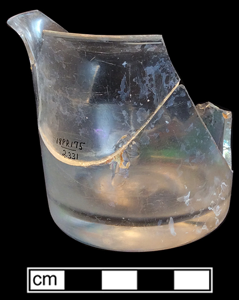 Colorless glass vessel with straight sides and a flaring rim.