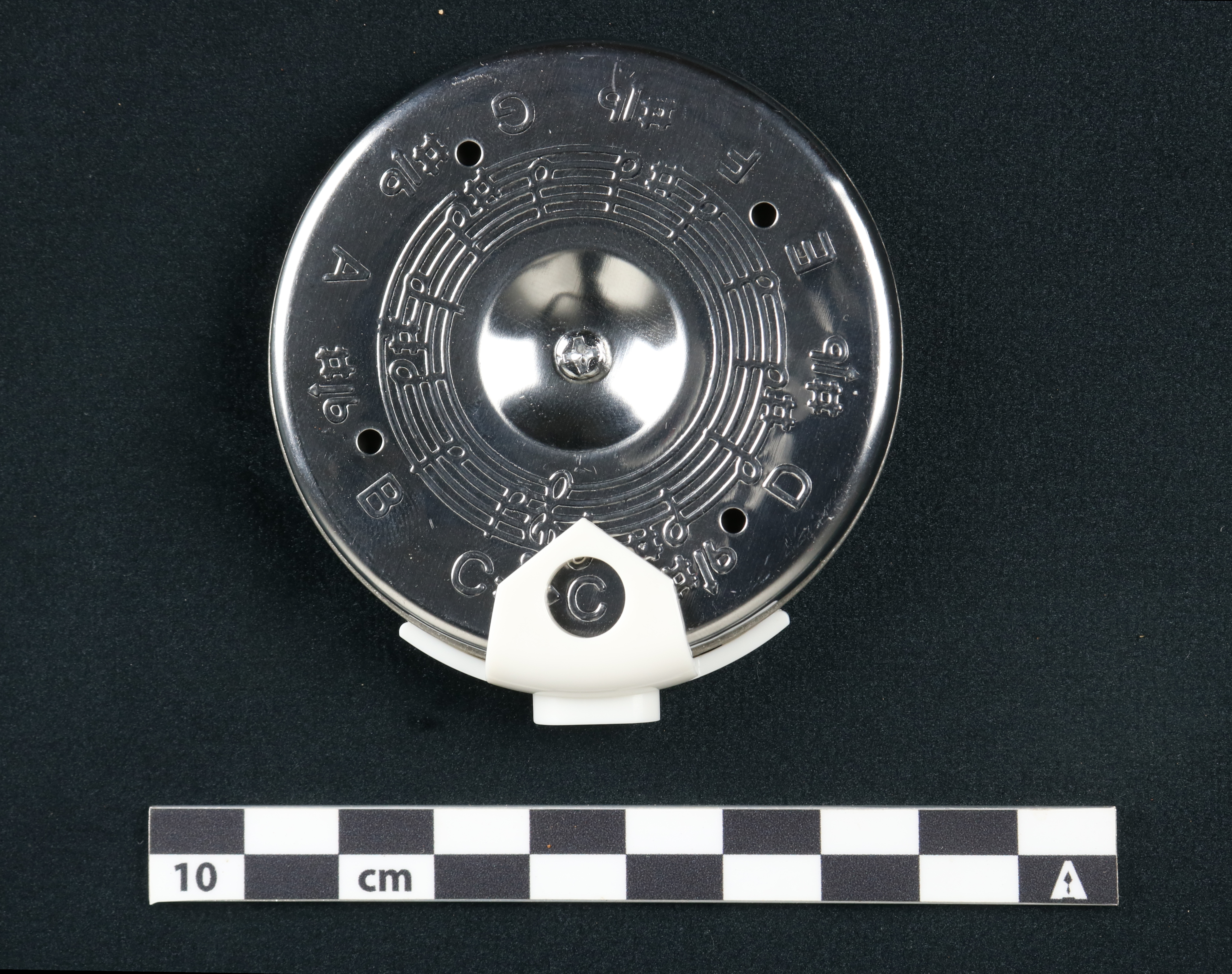 Figure 3 Round, chromed modern pitch pipe with plastic mouthpiece and text engraved into the
face of the case indicating all half notes of a musical scale around the diameter of the
pipe.