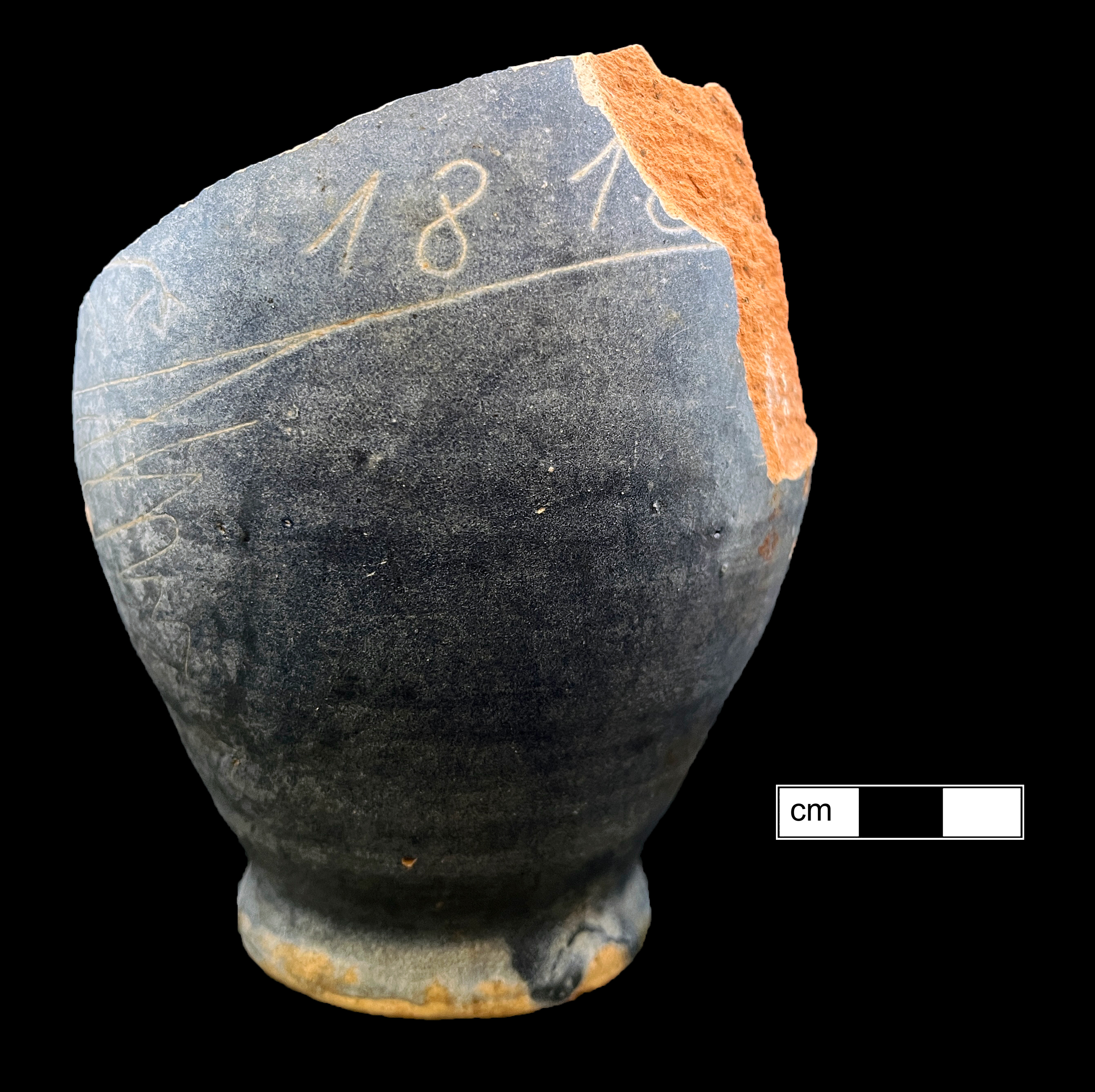 Side view of dark blue bulbous sided ceramic bottle with the date 181-- (either 1818 or 1816) scratched into the side.