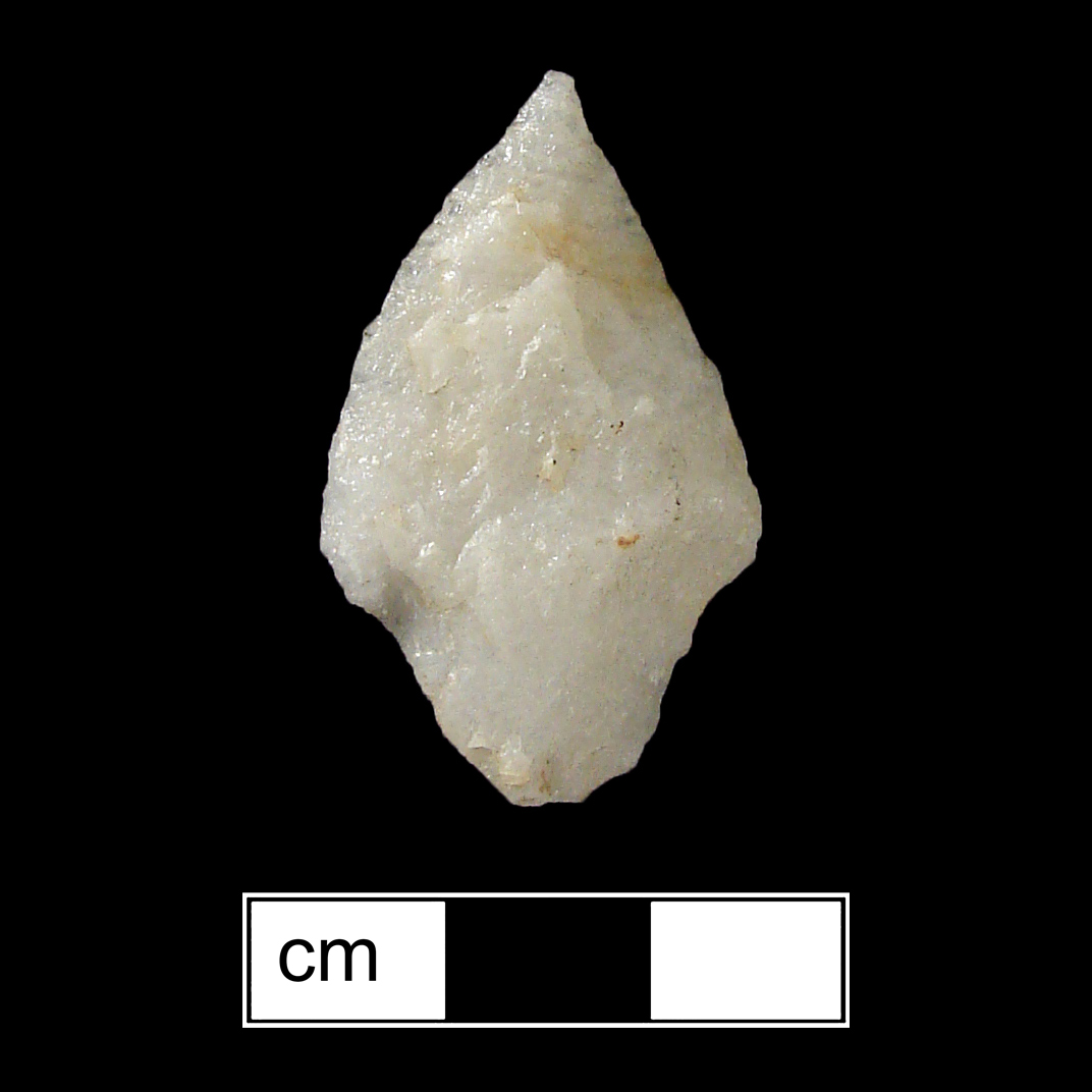 Image of stone projectile point made of Quartz, Contracting Stem shape, with a Contracting stem, Excurvate blade, and Convex base shape. Rossville type.