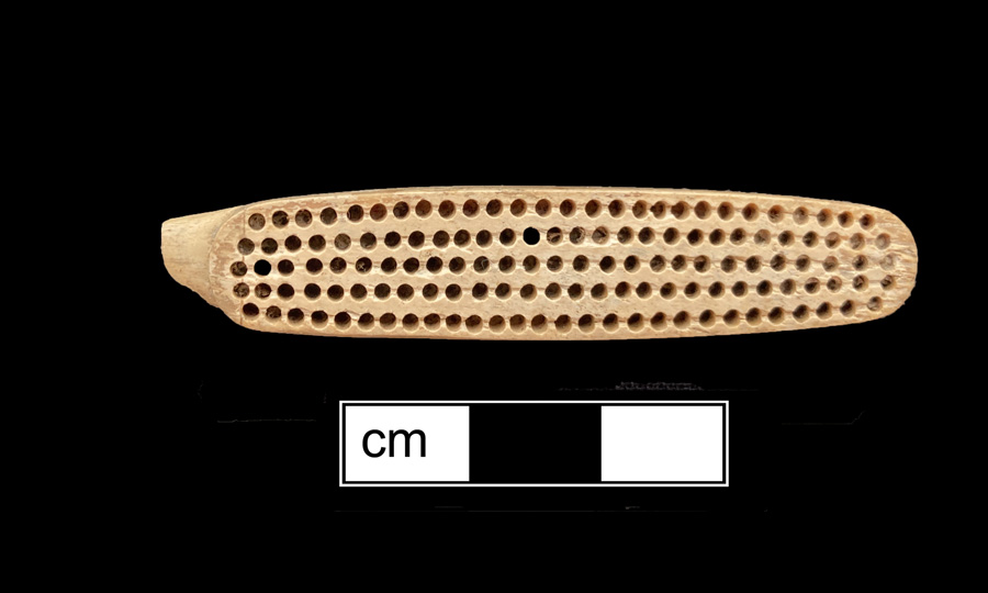 Image of bone toothbrush handle, trepanned.