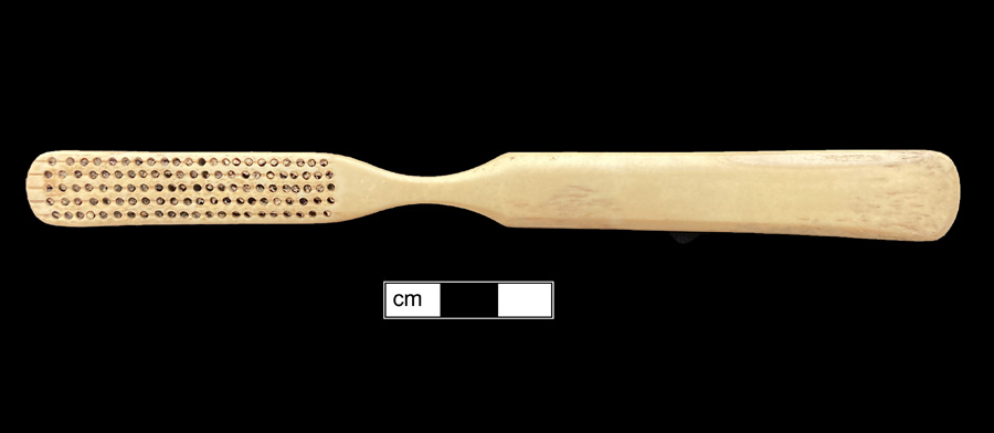 Image of bone toothbrush handle, trepanned, England type.