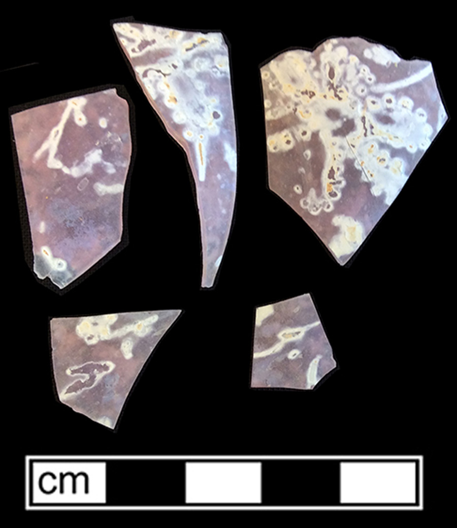 Image of opaque colored glass hollow vessel, adhesive decoration.