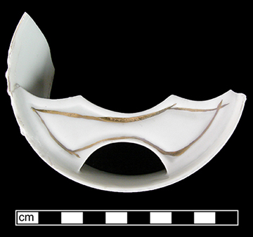European hard paste porcelain mustache cup  with molded decoration and gold gilt band embellishments and text &ldquo;Forget me not&rdquo;.  Printed marked base &ldquo;Made in Germany&rdquo; in circle, providing date of post 1891 for manufacture. 3.5&rdquo; rim diameter.