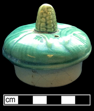Teapot molded with corn motif. This vessel displays a pink interior glaze.  Lid diameter: 2.50”, Vessel #: 67. 18BC56
