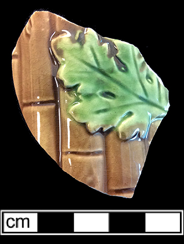Molded hollow vessel (jug?) with bamboo and leaf motif. Vessel diameter: approximately 4.00”. The interior of this vessel has a pale green lead glaze. 