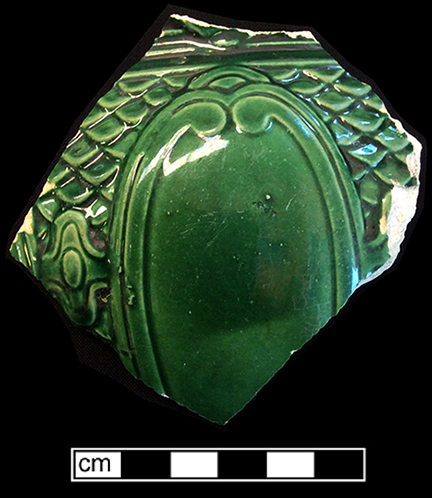 Molded hollow vessel (jug?) with a medallion motif. The interior of this vessel has a green lead glaze.