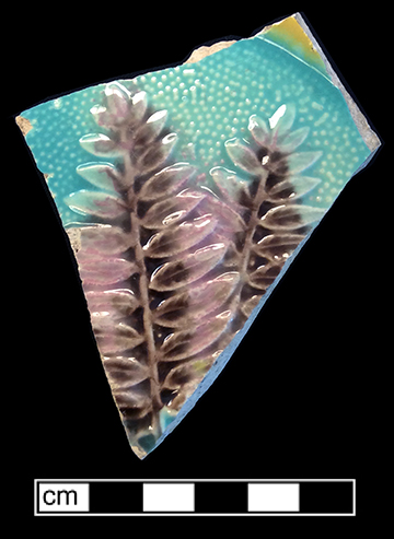 Molded plate with fern motif. Mayer’s Arsenal Pottery began producing majolica in the mid-1880s (Liebknecht 2005). The underside of this vessel has a mottled brown and green lead glaze.