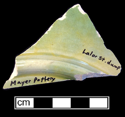 Molded flat vessel with leaf motif. The underside of this vessel has a mottled yellow and green lead glaze. 