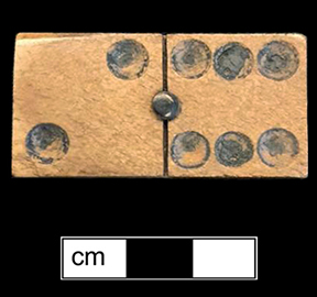 Wooden domino. Two types of wood riveted together from 18BC27, Feature 28. The game of dominoes  originated in China and made its way to Italy in the early 18th century. Game pieces were often made of ivory and ebony (The Strong).  