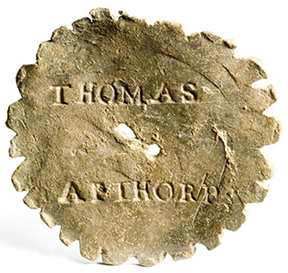 Lead whizzer. 1.25” diameter - from 18CV91. Shown on right is a whizzer recovered in Boston marked with name of Thomas Althorp. Courtesy of the City of Boston Archaeology Program.