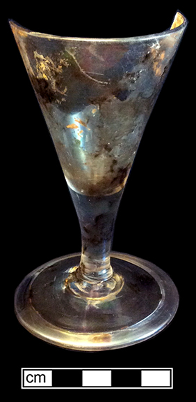 Colorless leaded stemmed glass with conical bowl, plain stem and folded foot. Empontilled.Rim diameter: 2.50”; Foot diameter: 2.50”; Vessel height: 4.50”. Lot 189-59. 18BC66.
