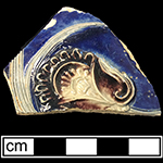Gray-bodied salt glazed stoneware hollow (mug or jug) with applied  floral motif and engraved stems. Cobalt-blue and manganese under the glaze. Vessel probably dates to second half of 17th century, based on the applied and incised motifs with cobalt blue and manganese from 18CV60.