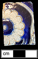 Gray-bodied salt glaze stoneware hollow vessel with incised foliage and stamped rosette outlined in cobalt-blue under the glaze from 18CV60.