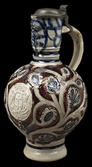 Gray-bodied salt glazed stoneware hollow (mug or jug) with applied  floral motifs painted in cobalt-blue and manganese under the glaze, from 18CV60. Complete vessel with similar motifs shown.