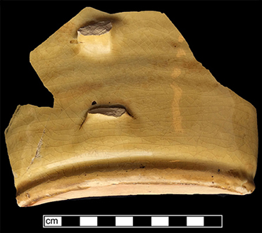North Midlands slip decorated handled cup.&nbsp;Interior decorated with &ldquo;jeweled&rdquo; dots of slip typical of late 17th- and early 18th-century vessels. Decorated in white and brown slip, Glazed interior (left) and exterior (middle). Base diameter:&nbsp;5.75&rdquo; Lot 229. Paste shot shown on right - from 18CV169. 