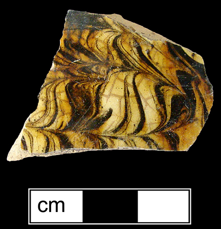 North Midlands combed slipware hollow vessel, probably cup or mug.  Glazed interior and exterior - Collected by George L. Miller in 1986 in Staffordshire, England.