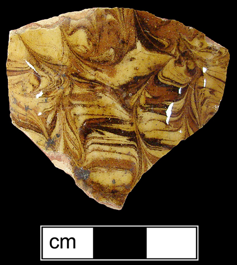 North Midlands combed slipware hollow vessel, probably cup or mug.  Glazed interior and exterior -  Collected by George L. Miller in 1986 in Staffordshire, England.
