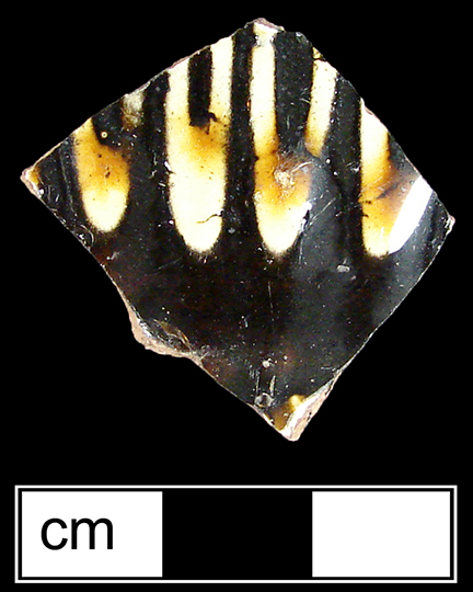 North Midlands reverse slip decorated hollow vessel of indeterminate form. Vessel covered with brown slip, with white slip trailed decoration applied over brown slip on vessel exterior - Collected by George L. Miller in 1986 in Staffordshire, England.