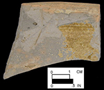 North Devon Gravel-free Coarse Earthenware Hollow (probable pan). Lead glazed interior (left); unglazed exterior (right), approximately 10&ldquo; rim diameter. Damage to the left side of the sherd reveals the grey inner core caused by oxygen reduction during firing. Square 2855.