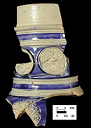 Gray-bodied salt glaze stoneware jug with applied (sprigged) floral motifs with cobalt blue painted under the glaze.  Cordoned neck. 2.25&rdquo; rim diameter. Lot numbers:  18CV271-8, 83, 86, 146, 234, from 18CV271.