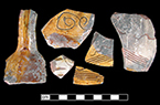 North Devon Sgraffito jug with incised spiral (curlicue) and linear motifs. White slip over red earthenware body, with lead glazed interior.  Vessel 34. Lots 601, 636, 720, 725.