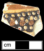 North Midlands slip decorated flat vessel of indeterminate form (probably dish or plate).  �Jeweled� dots of slip typical of late 17th and early 18th century vessels.  Decorated in white, red and brown slip. Glazed interior, unglazed exterior - Collected by George L. Miller in 1986 in Staffordshire, England.