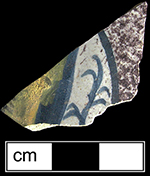Bowl with purple powdering around an unidentified motif (most likely a fish) in blue and yellow.