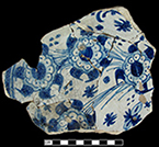Charger painted with blue floral motif and with lead glaze over a tin glaze on the vessel underside.