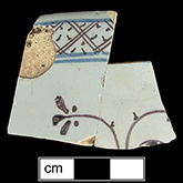 Punch bowl painted in blue and purple. Dot and diaper motif usually used as part of border or rim motif and is indicative of Chinese design influence on tin-glaze.