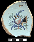 Tin glazed earthenware bowl painted on the interior base with blue, green and red floral motif. Base diameter:  3.25” - from 18QU124.