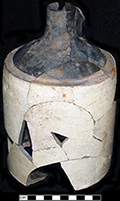 North American buff bodied stoneware jug with Albany slipped shoulder, neck and handle. Bristol glaze covers the cylindrical body. 2 quart capacity. Damaged from burning. Vessel height: 9.00”,Vessel diameter: 5.50”, Vessel V-16 from 18MO609.