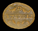Oval colorless inset with a smooth rounded cabochon top and a back molded with the word “LIBERTY” in reverse so that it would show through the inset. 