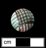 Unglazed porcelain marble decorated with intersecting sets of parallel lines in red and green. This decorative motif was common from c.1850 to 1910 - click image to see larger view.