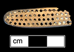 Stock end shows trepanned tunnels that ran the length of the stock. These holes were plugged with wax or cement; in this case some of the plugs are still intact. Guideline channels for drilling the bristle holes are also visible along some of the rows. Trench 1-A, Level 3. Lot 11. 18BC92