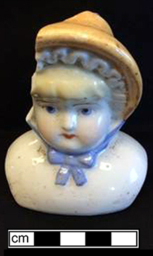 Painted hard paste porcelain Bonnet doll. Bonnet dolls mostly date from after 1885 (King 1981:306).&nbsp;This porcelain head would have been attached to a cloth body and would have had porcelain arms and legs. A similar doll shown on right made by the Hertwig Company (1864-1941), Germany, circa 1900 - from 18BC27.
