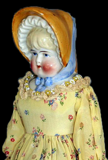 Painted hard paste porcelain Bonnet doll. Bonnet dolls mostly date from after 1885 (King 1981:306).&nbsp;This porcelain head would have been attached to a cloth body and would have had porcelain arms and legs. A similar doll shown on right made by the Hertwig Company (1864-1941), Germany, circa 1900 - from 18BC27.