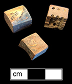 Unfinished bone die.  This example is one of seven unfinished dice or game pieces recovered from this privy.  The die has been shaped and markings made for the placement of the dots, for later drilling.  Each of the pieces has split or shows damage that led to its being discarded before completion. 18BC80